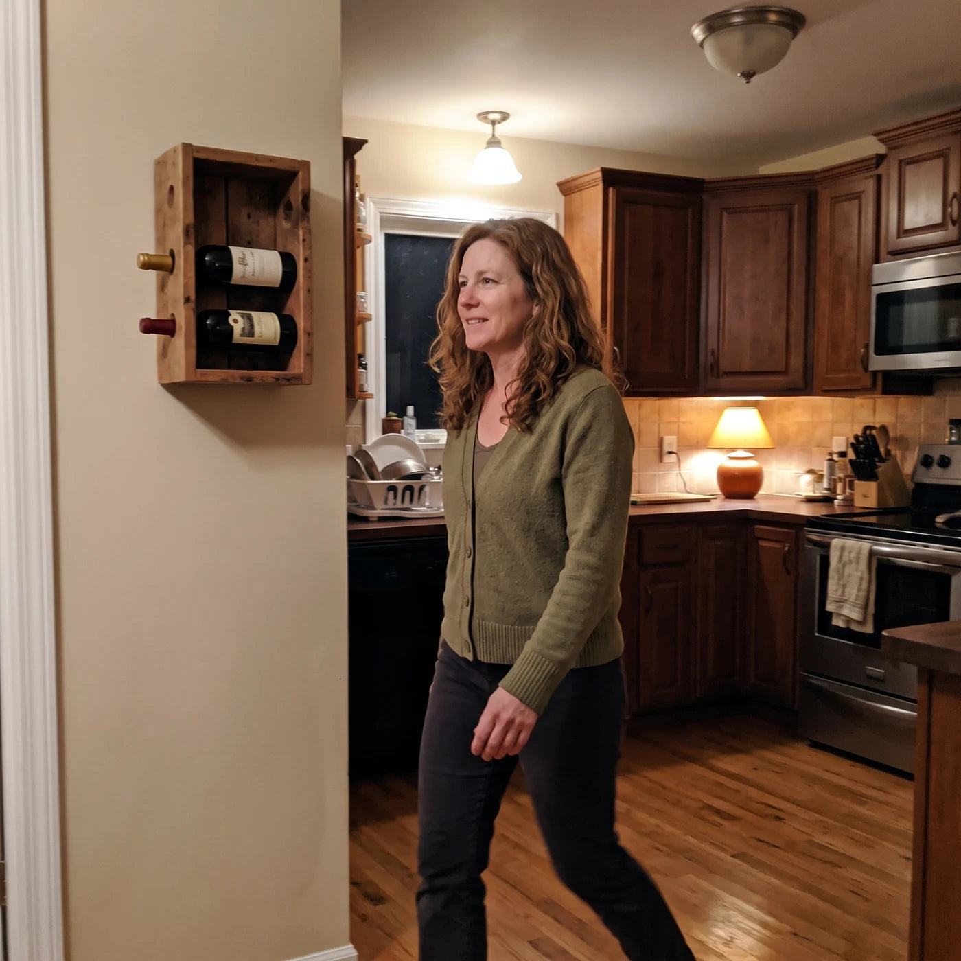 Woman walking through her kitchen past a wine rack, not reaching for it