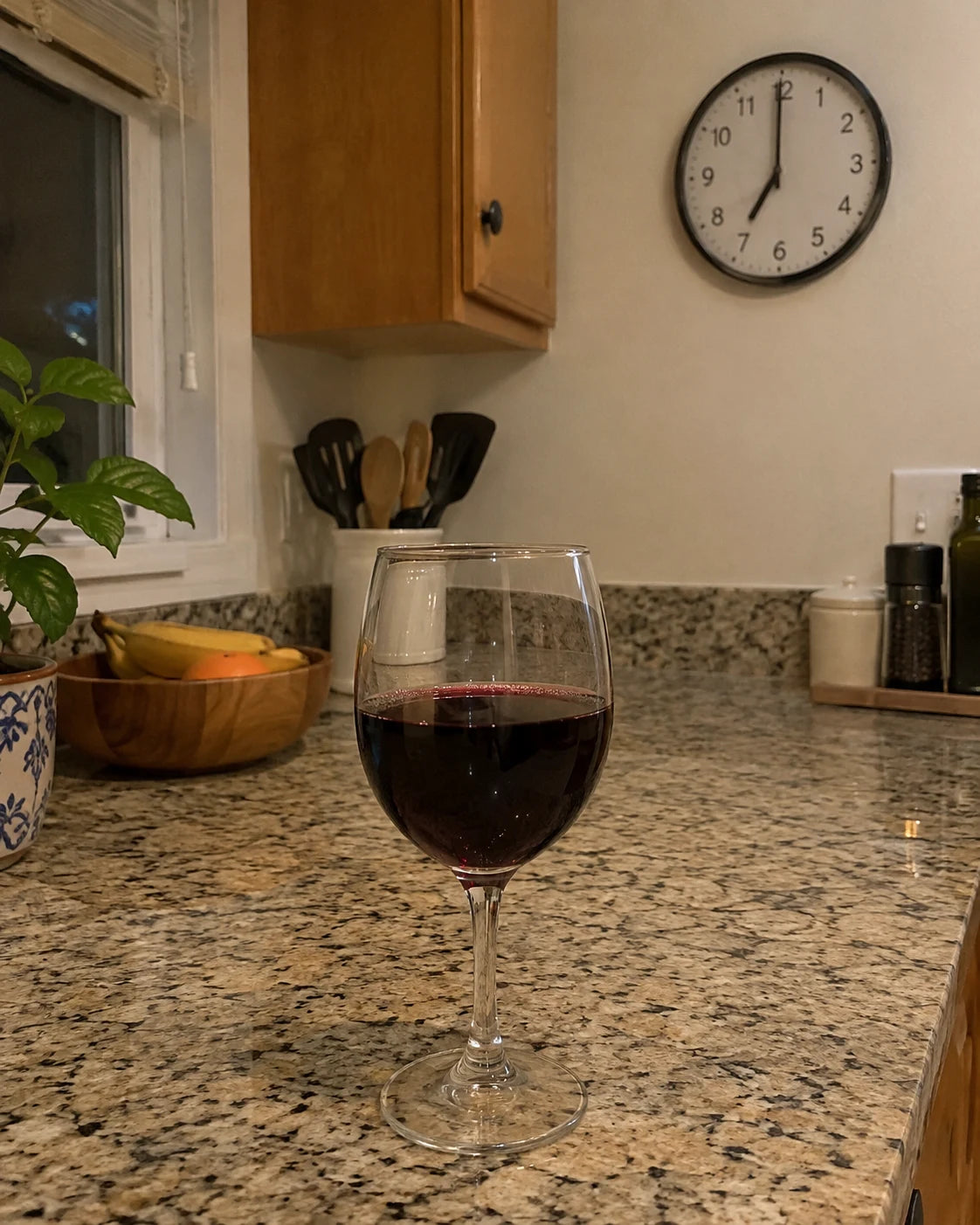 A full glass of wine alone on a kitchen counter at 7pm