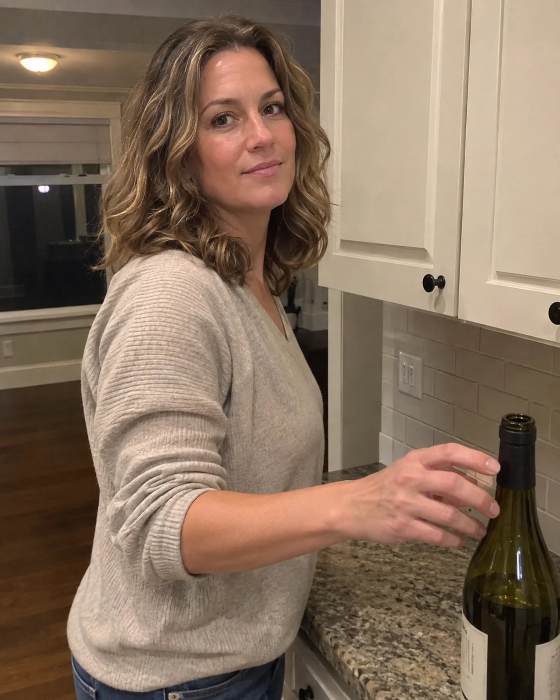 Hand reaching automatically for a wine bottle in the kitchen
