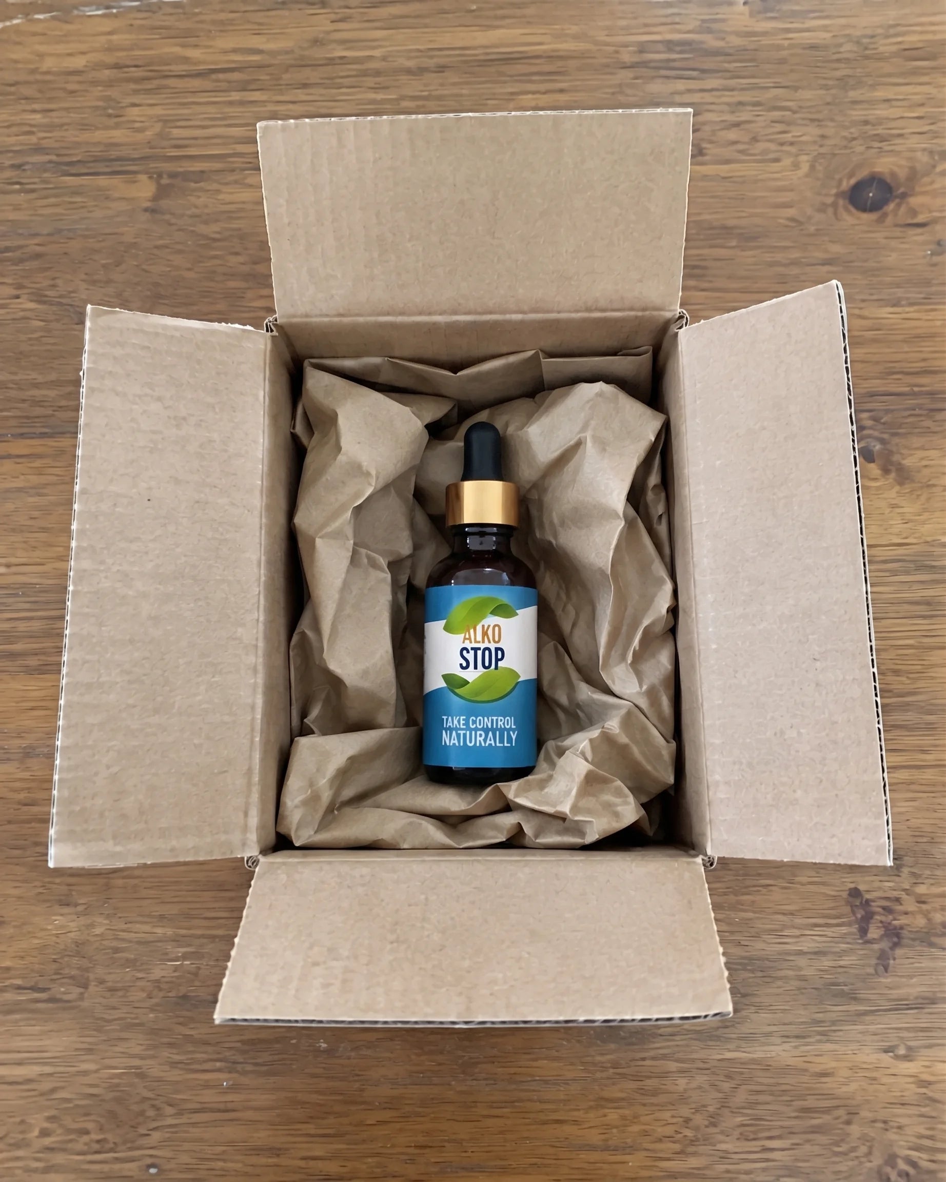 An AlkoStop dropper bottle sitting in an opened shipping box with packing paper
