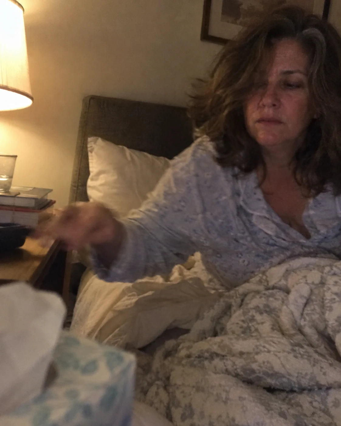 A tired woman lying awake in bed at night