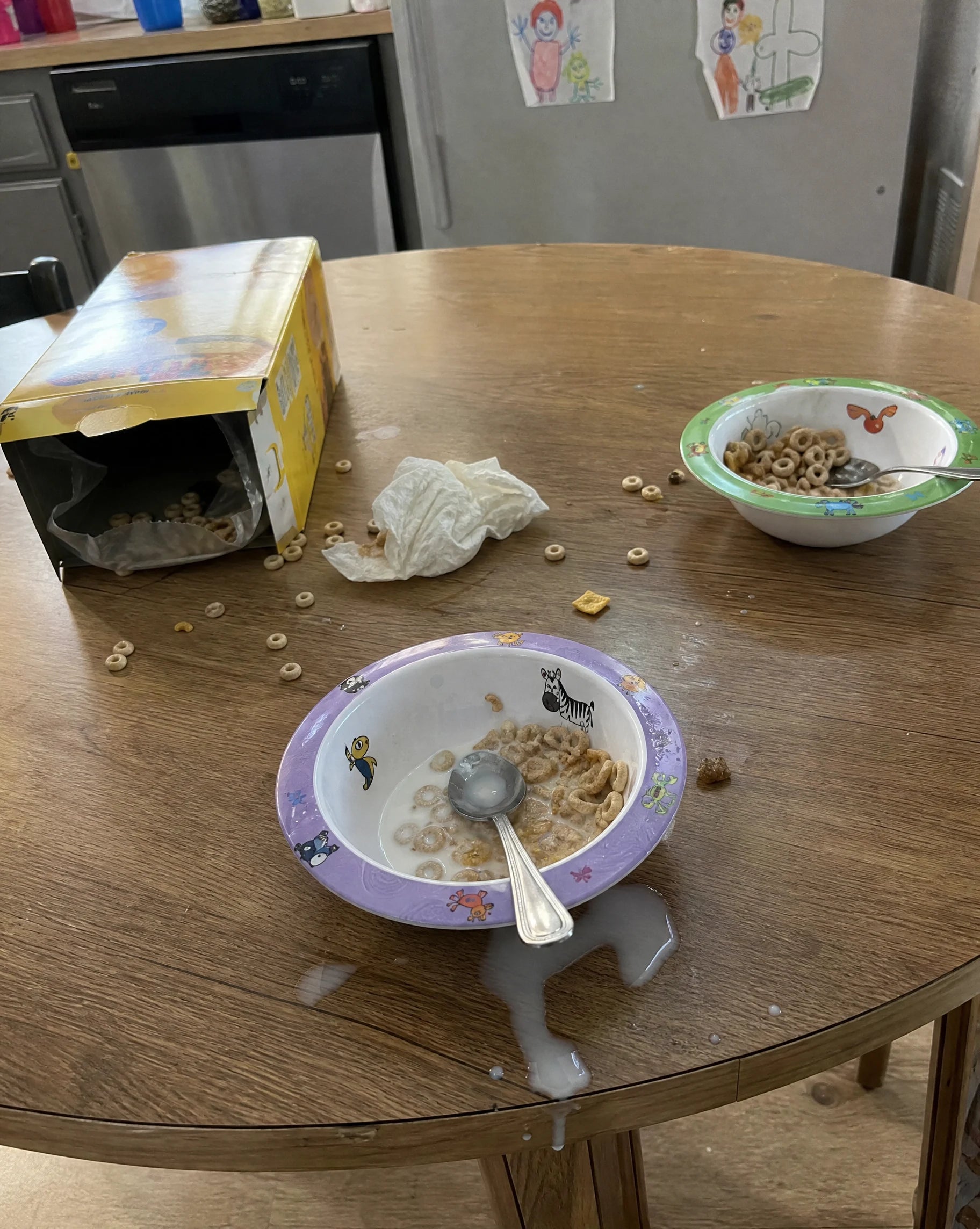 Messy kitchen breakfast table the morning after, spilled milk and cereal, no adult present
