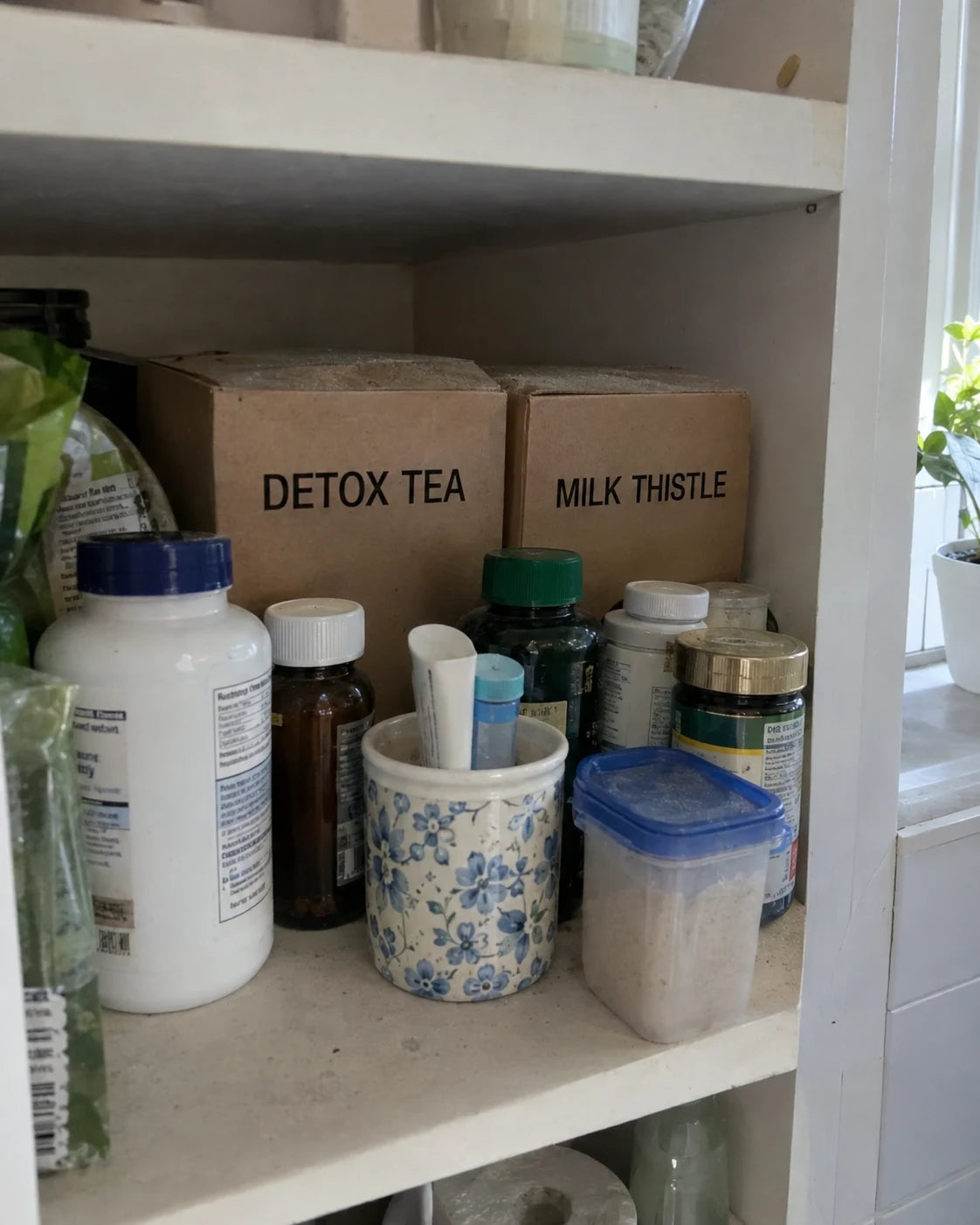 Unopened herbal tea boxes and a supplement bottle pushed to the back of a dusty shelf