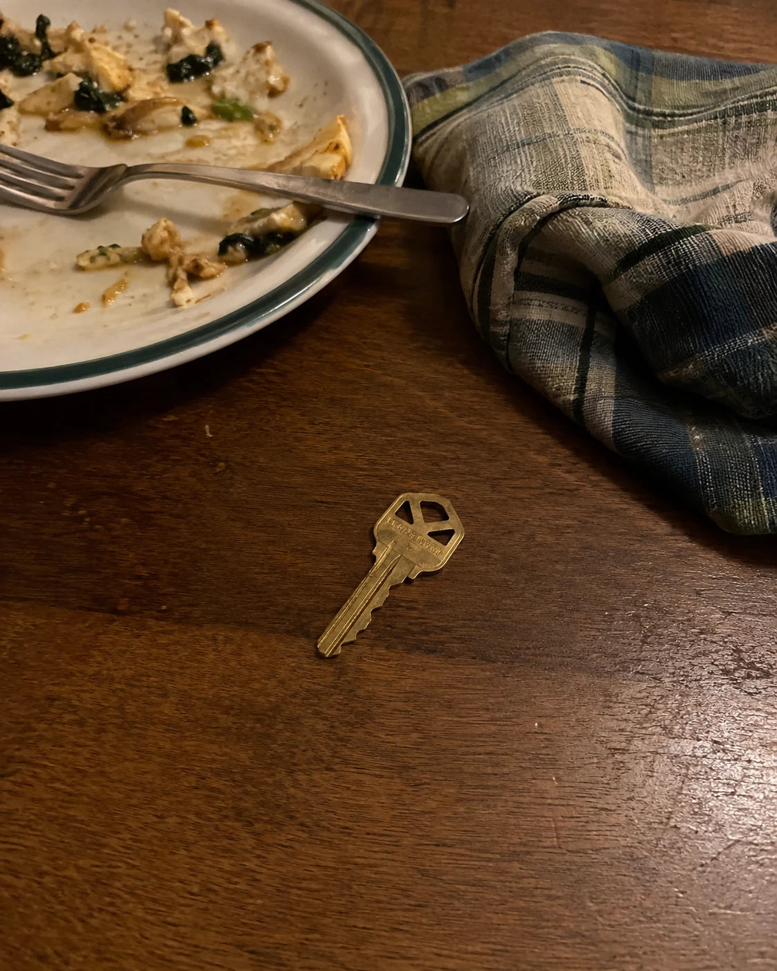 A house key resting on a dinner table