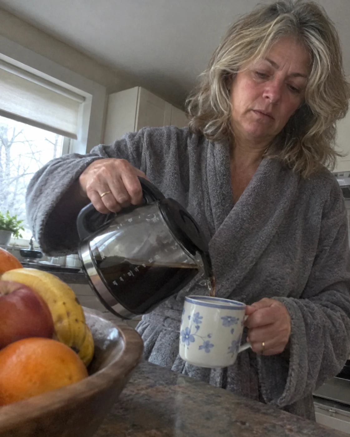 Woman looking tired while pouring coffee in the morning
