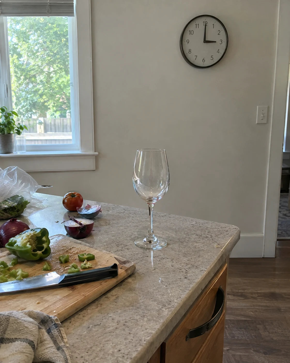 An empty wine glass on the kitchen counter at 3pm, hours before dinner