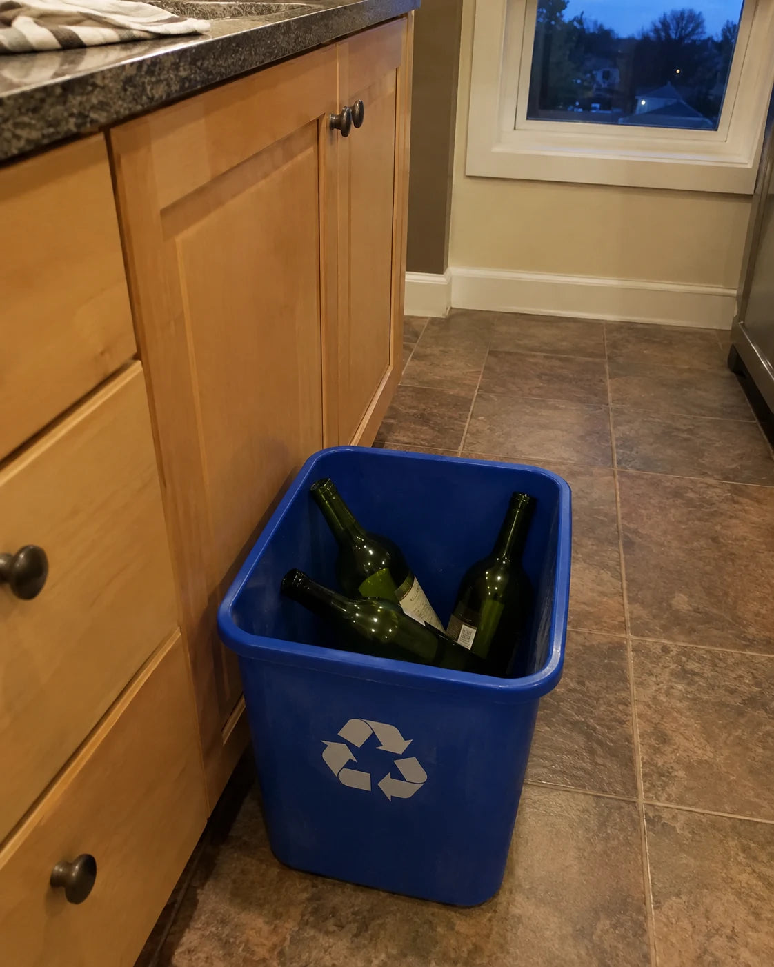 Empty wine bottles in the recycling bin at dusk