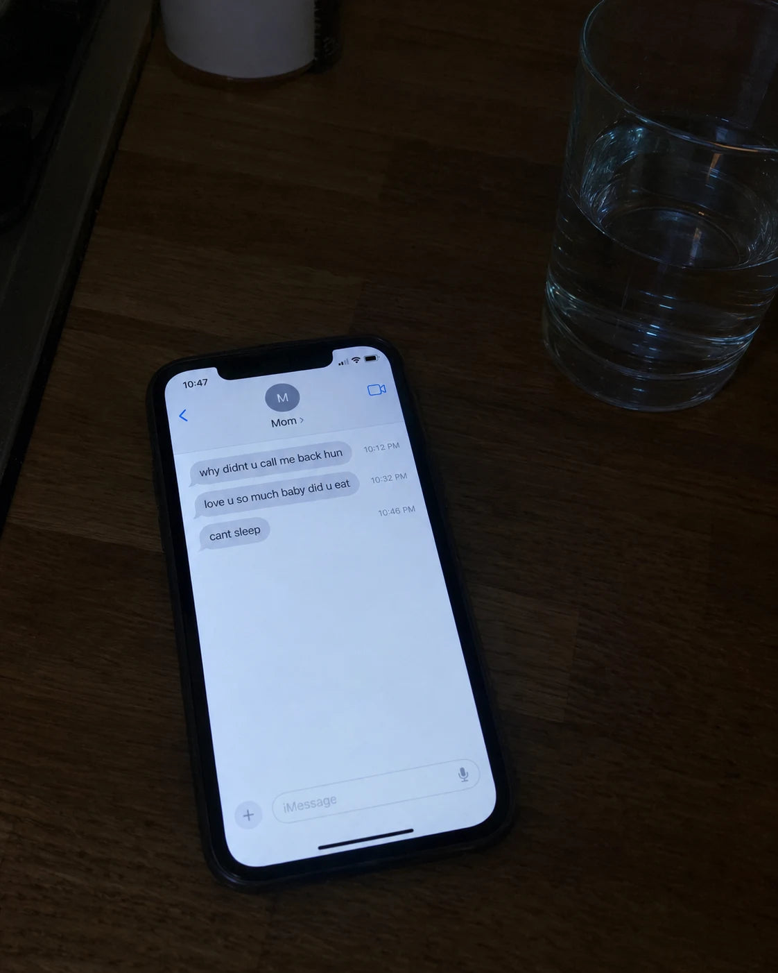 Phone lighting up with a text message on a dark kitchen counter at night