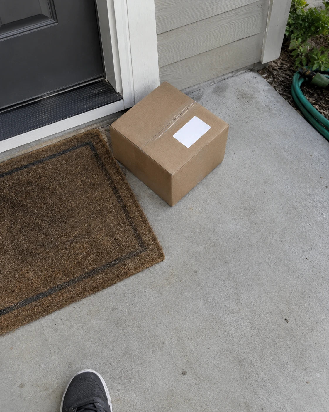 Plain unmarked cardboard package delivered to a front porch