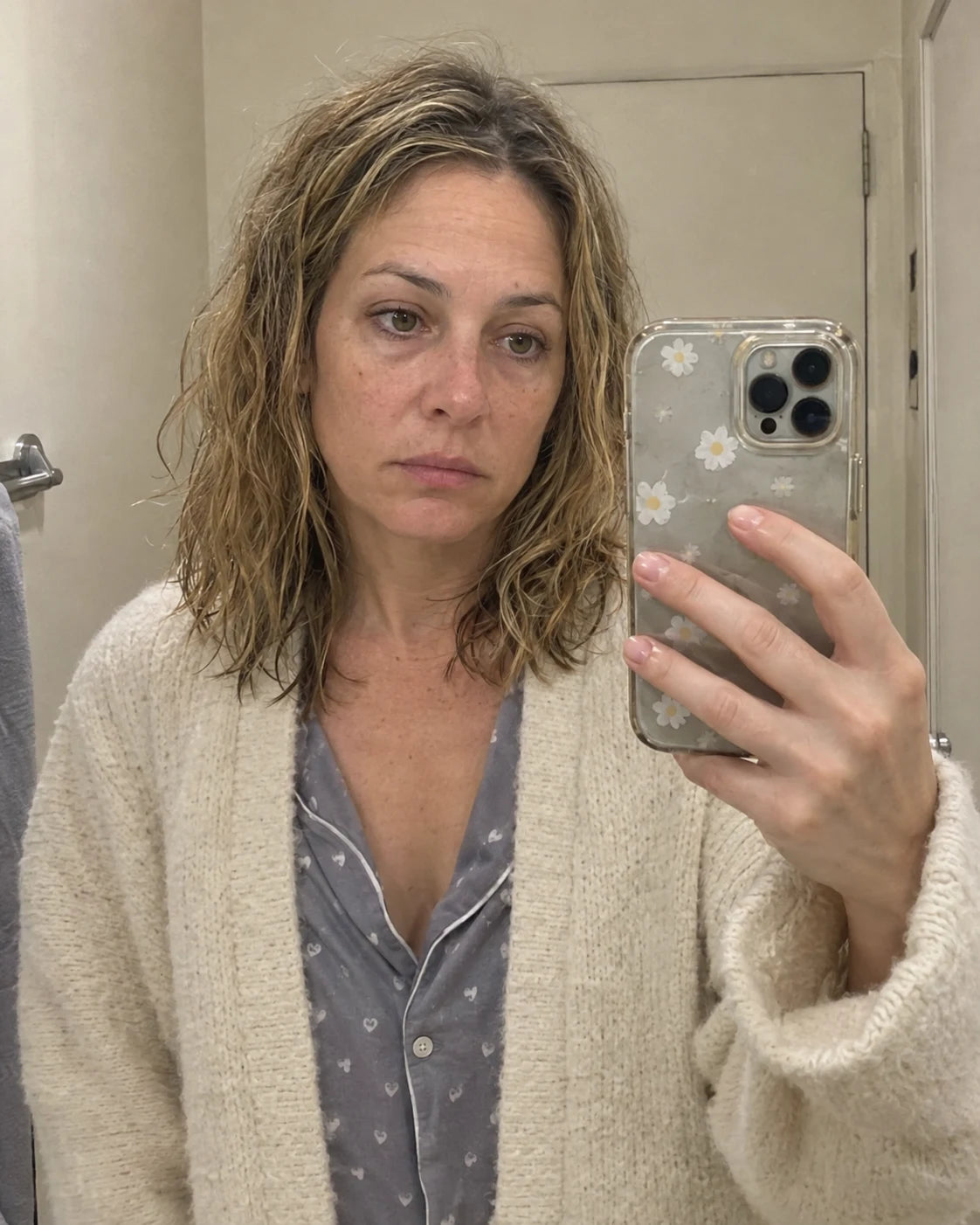 Woman looking at her tired reflection in the mirror