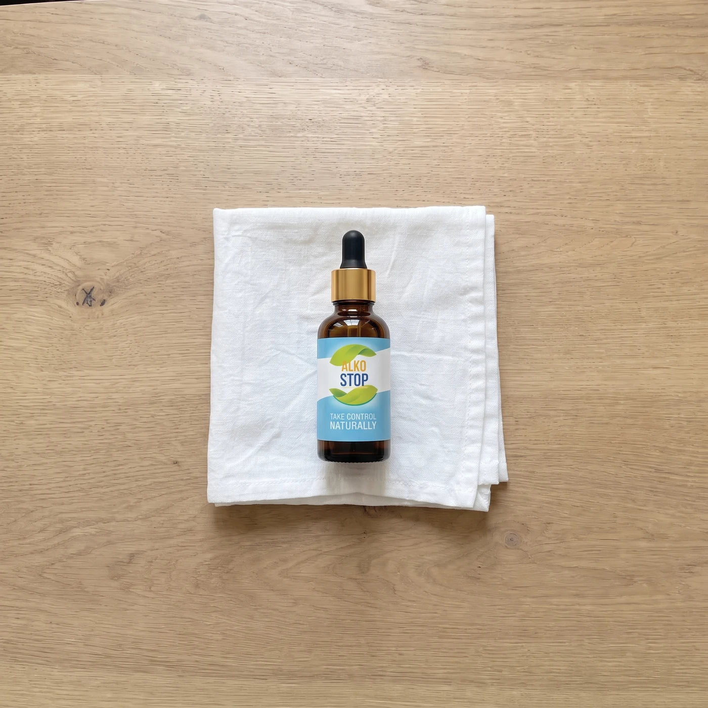 AlkoStop dropper bottle resting on a folded white linen cloth