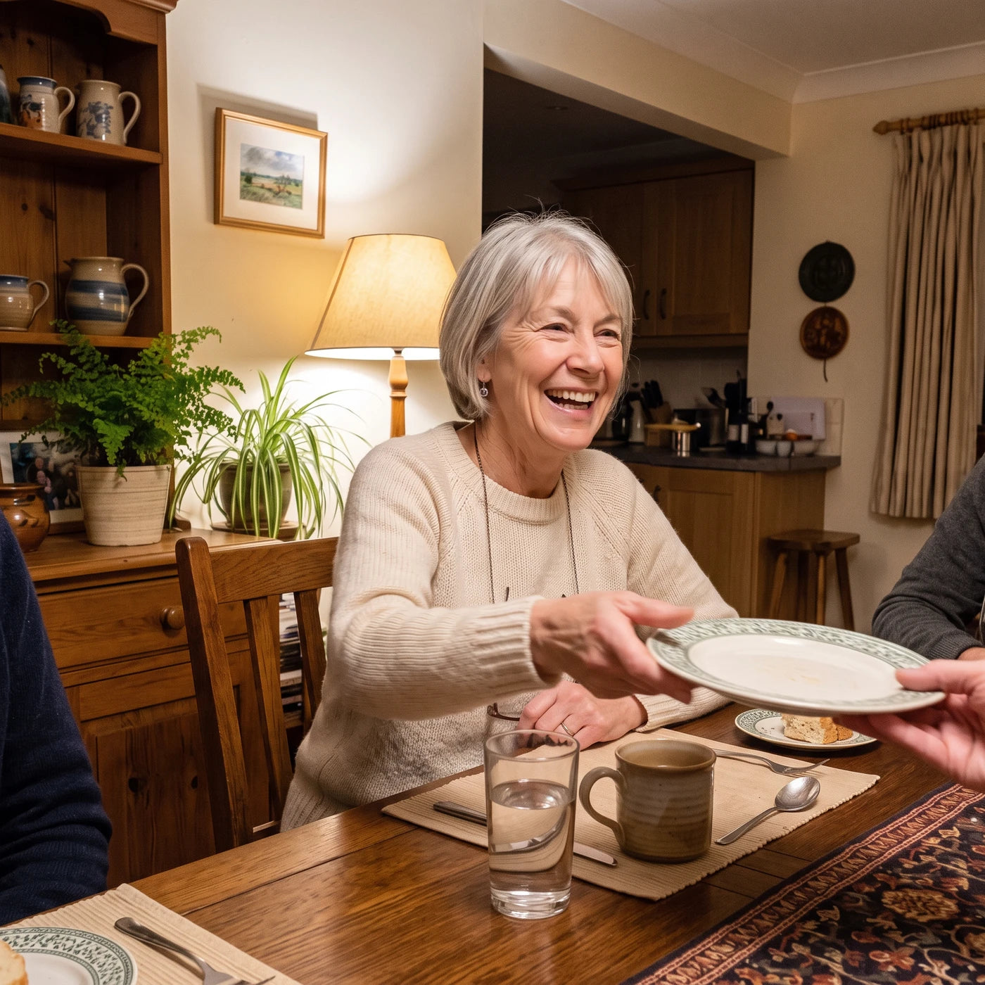 Maya's mom laughing at the dinner table, passing her plate for seconds