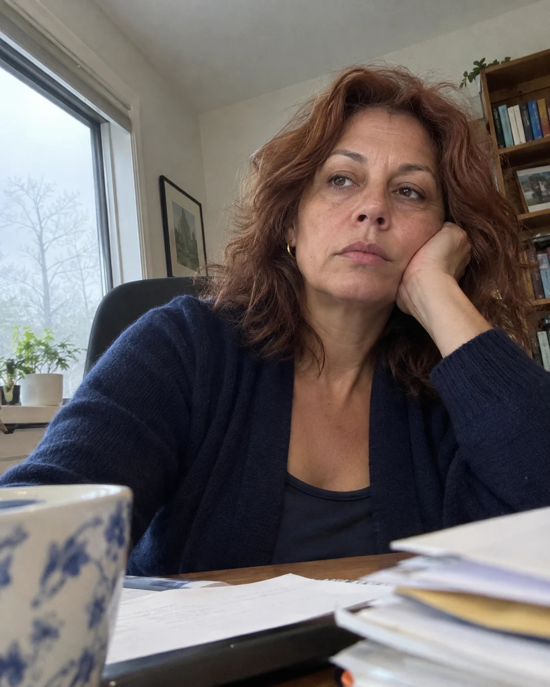 Woman looking flat and unfocused at her desk in the afternoon
